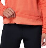 a women wearing a orange essential hike grid half zip fleece