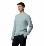 a man wearing a blue tech trail utility warm long sleeve crew shirt