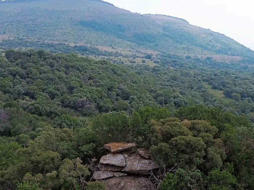 Lush green hills and rocky outcrop.